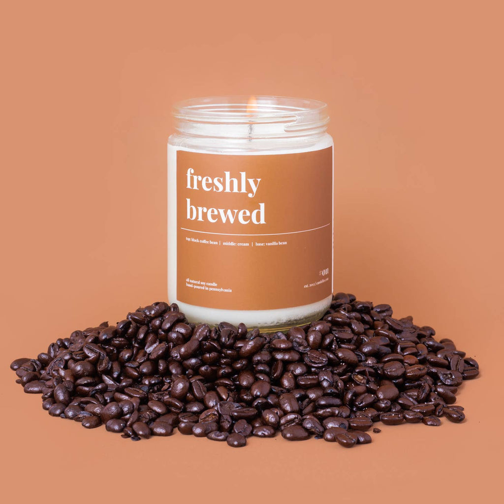 Freshly brewed candle sitting on a pile of coffee beans